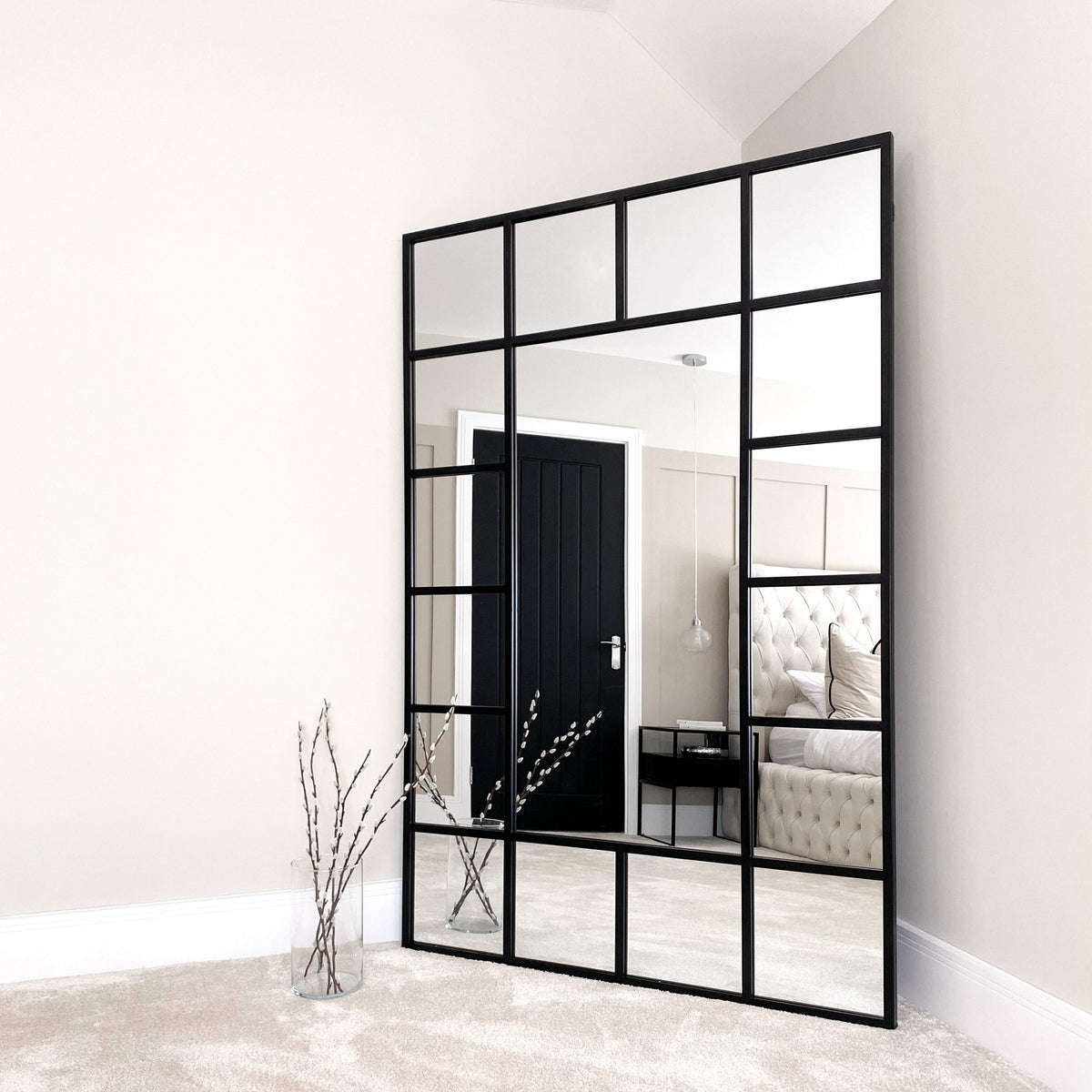 Black industrial full length metal window mirror in lounge corner