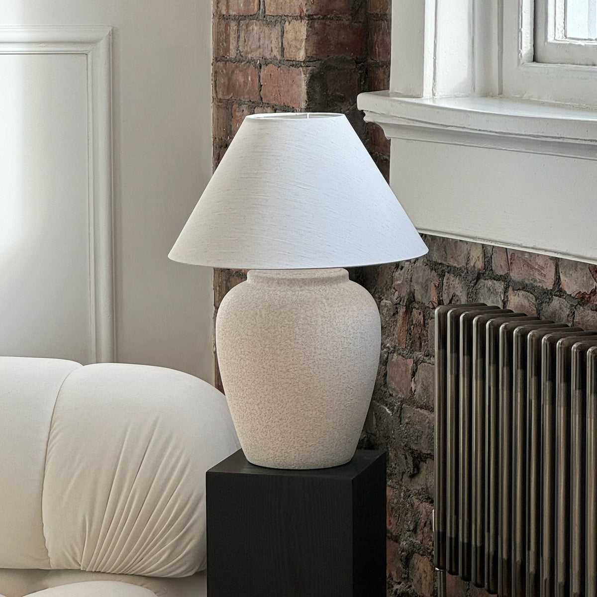 Stone Ceramic Coolie Shade Table Lamp on black pedestal