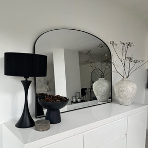 Black metal overmantle large wall mirror displayed on console table