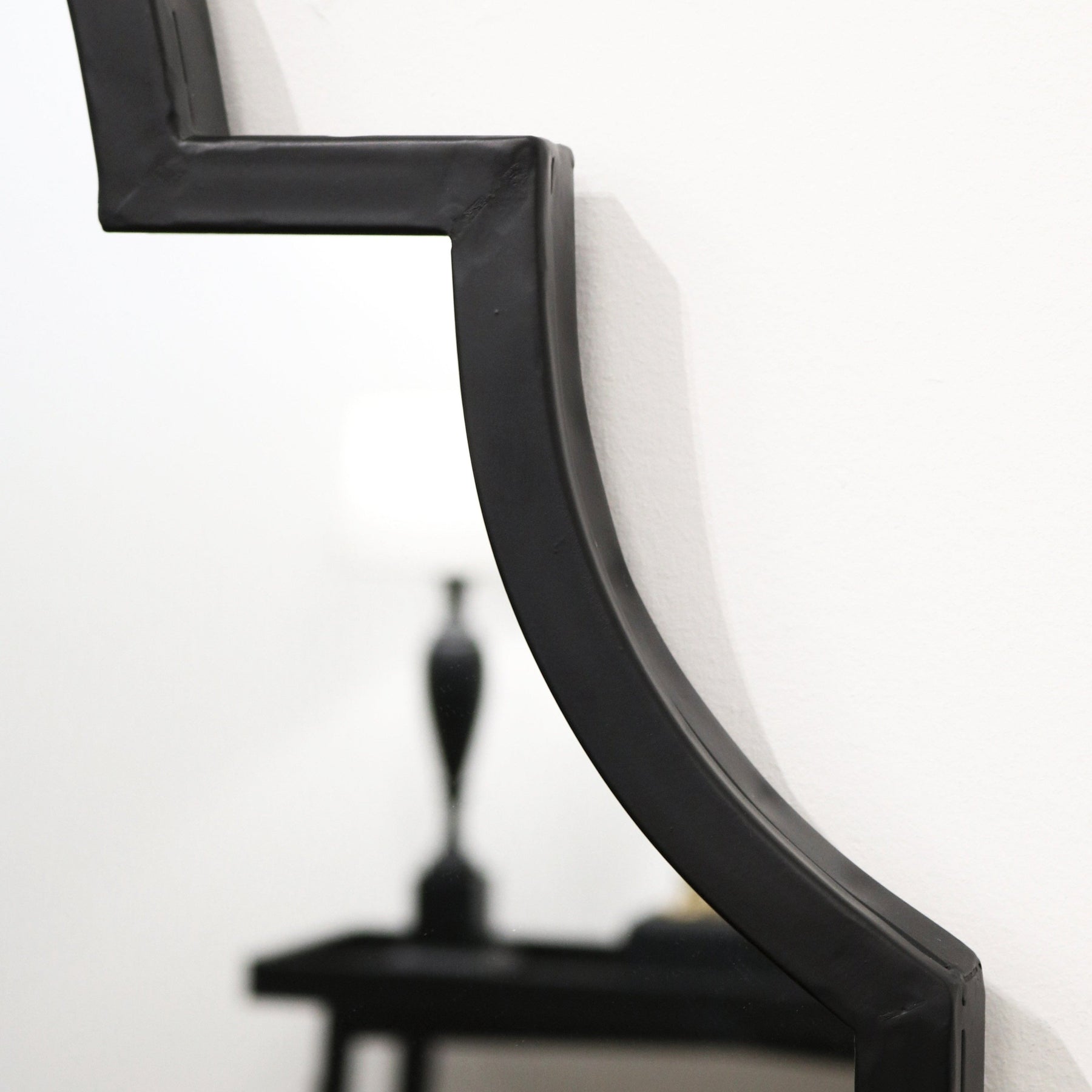 Closeup of Black industrial arched metal full length mirror