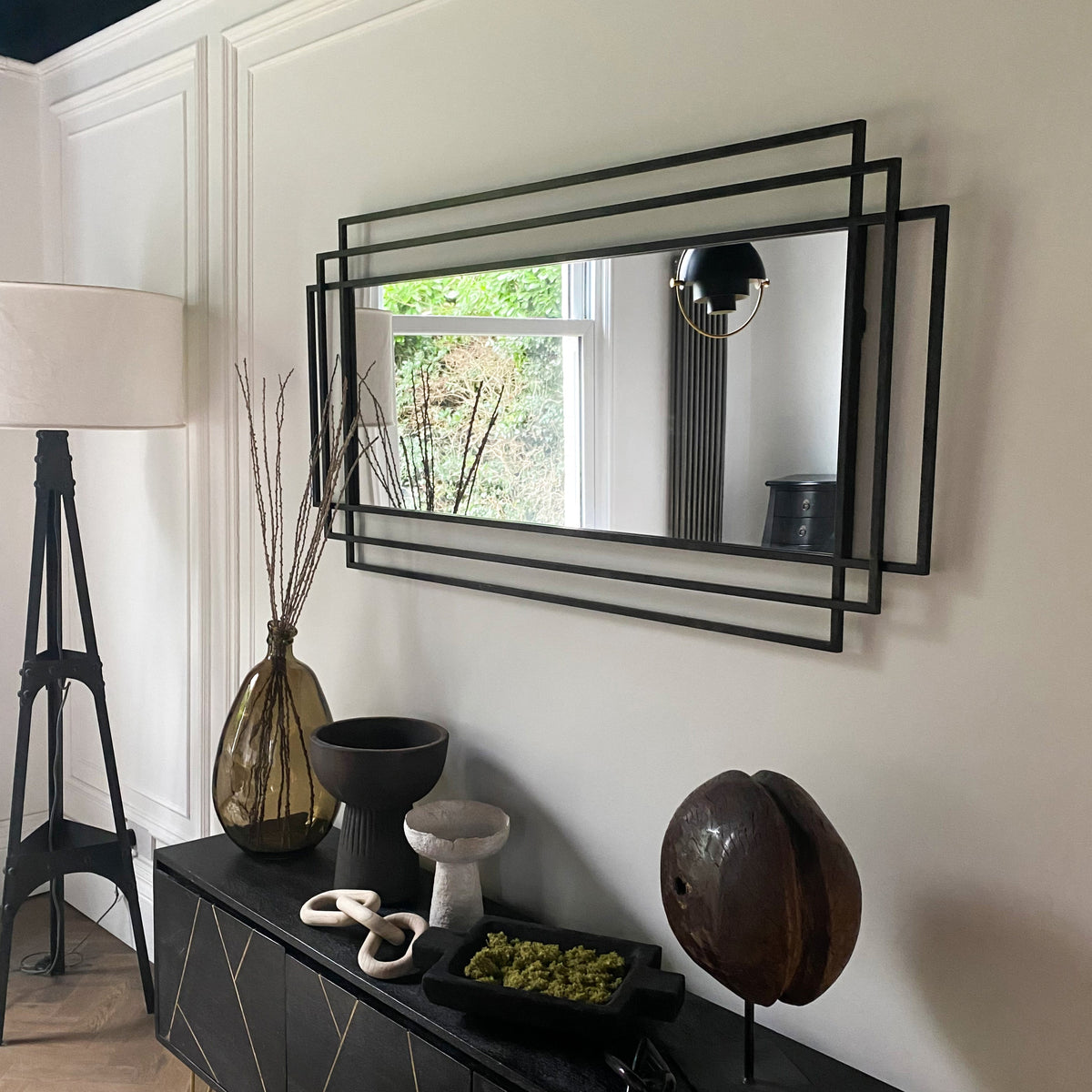 Large black rectangular metal mirror displayed on wall