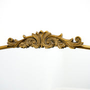 Closeup of extra large gold ornate arched metal mirror