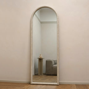 Large arched concrete mirror leaning against wall