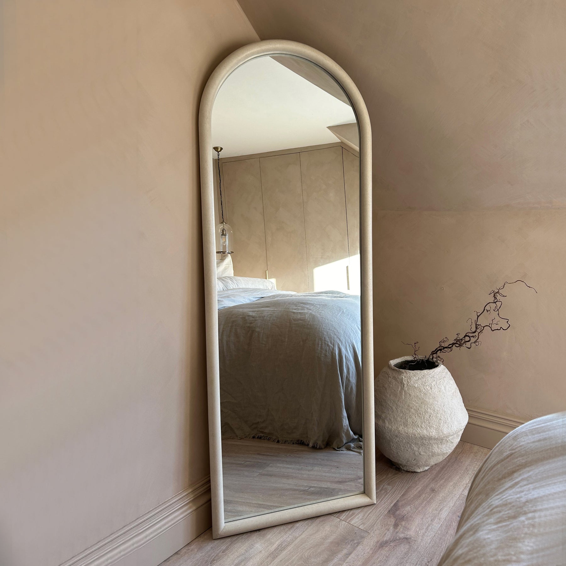 Large arched concrete mirror leaning against wall