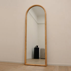 Full length large arched natural mirror leaning against wall