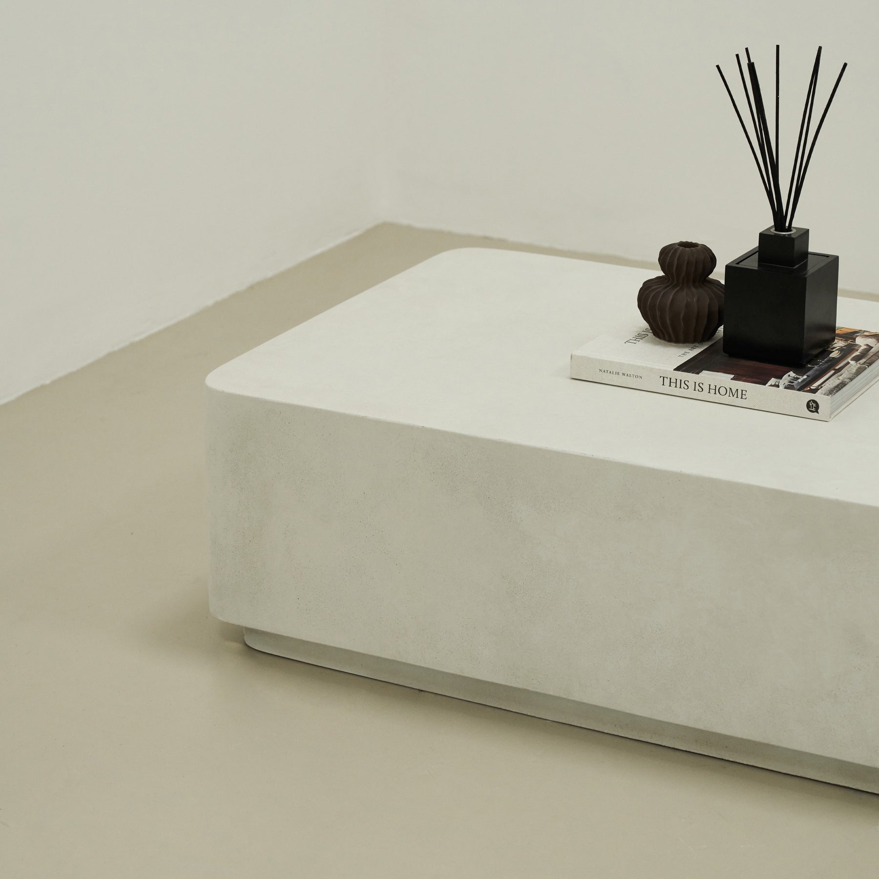 Minimal Concrete Rectangular Coffee Table Large adorned with books, pots, and incense