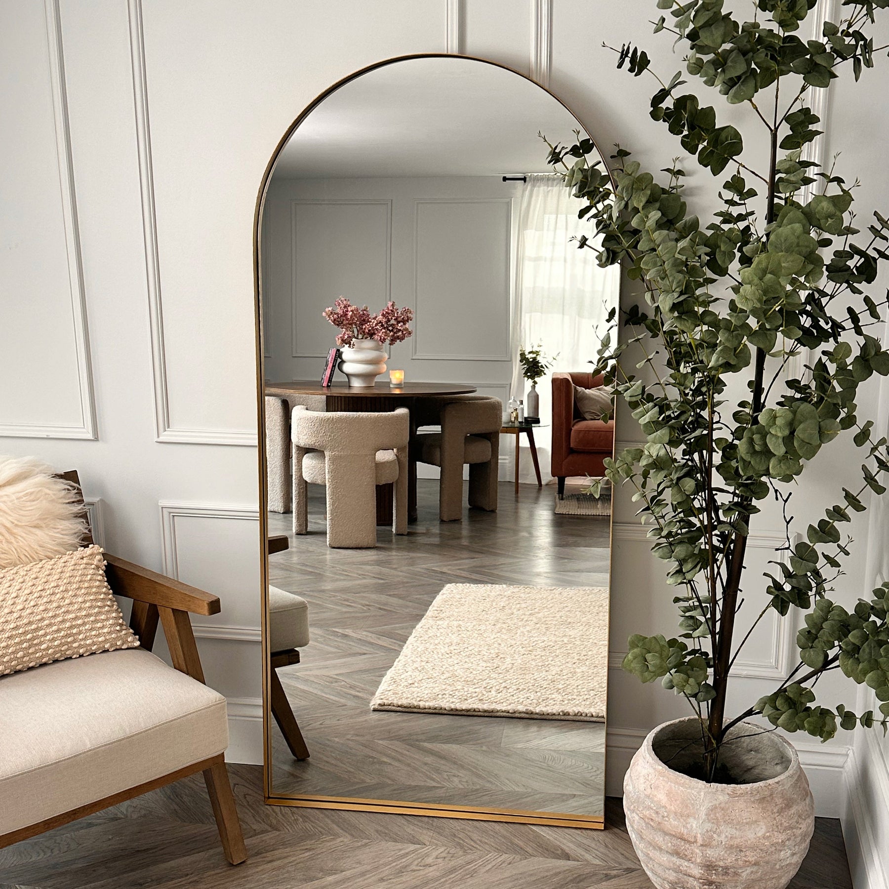 Full length arched gold large metal mirror leaning against wall