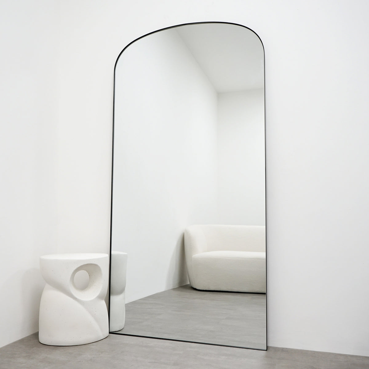 Full length black large metal mirror leaning against wall