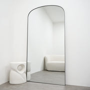 Full length black large metal mirror leaning against wall
