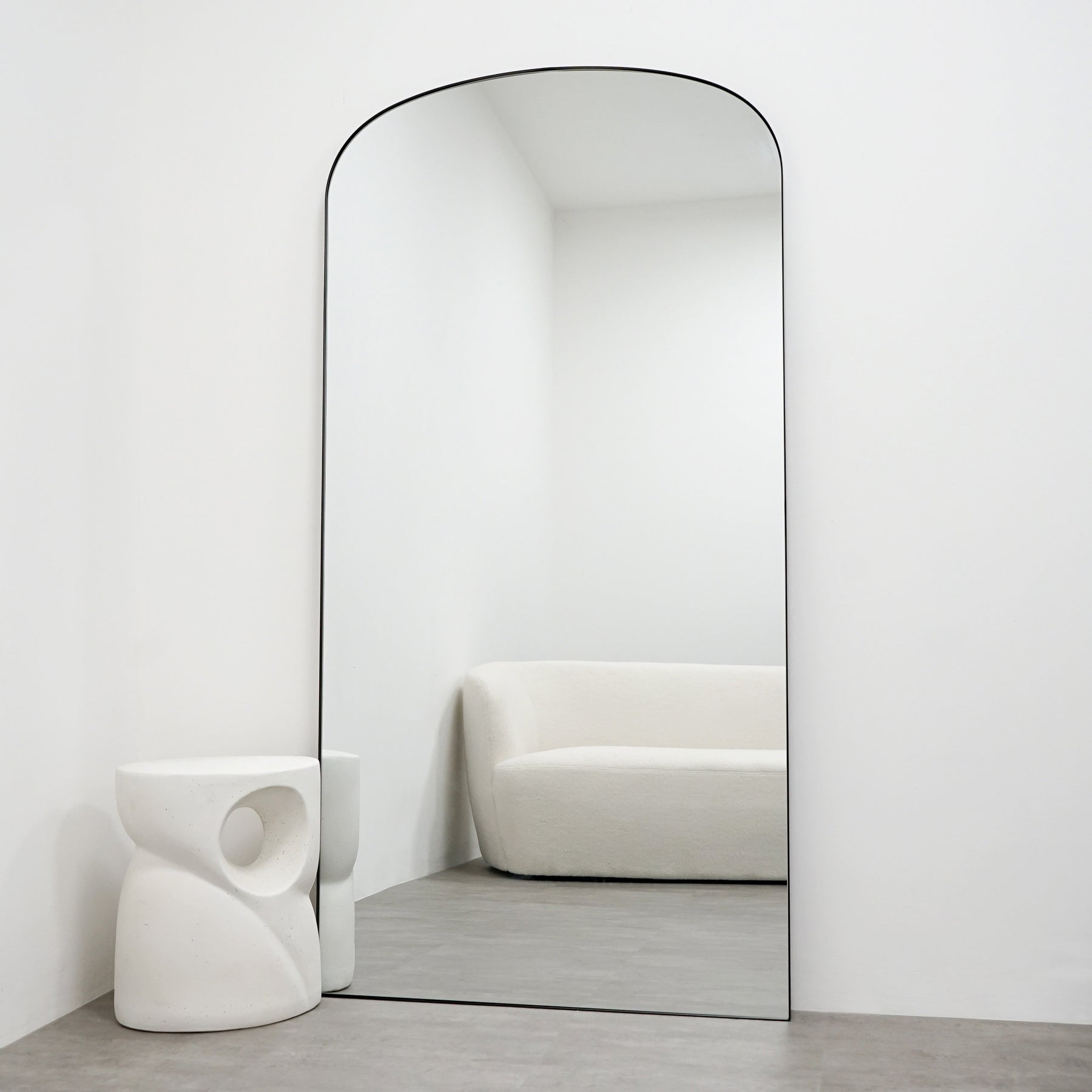 Full length black large metal mirror leaning against wall