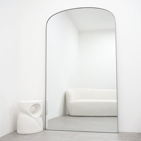 Full length black XXL metal mirror leaning against wall