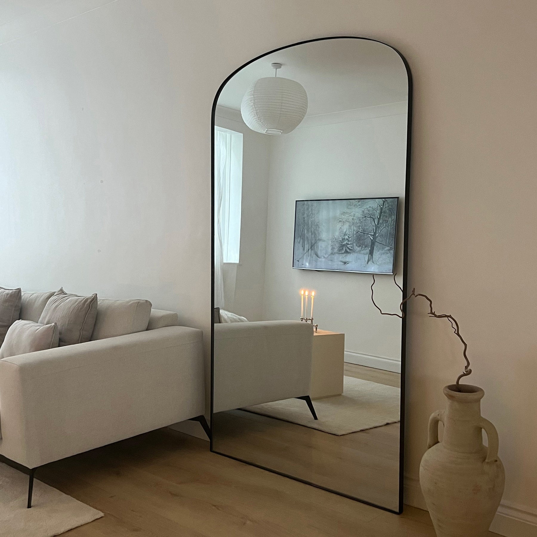 Full length black extra large metal mirror leaning against wall