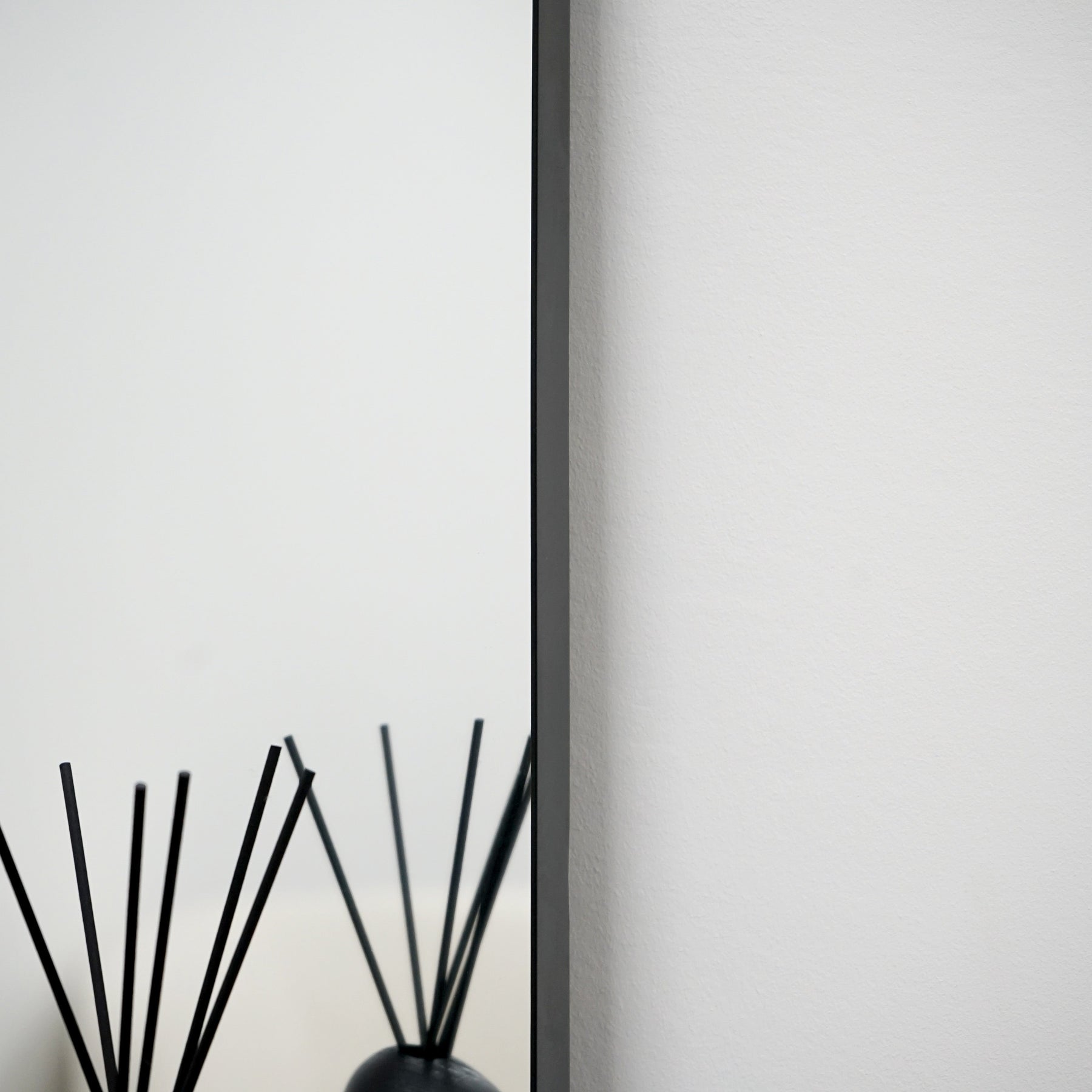 Closeup of Black metal overmantle wall mirror