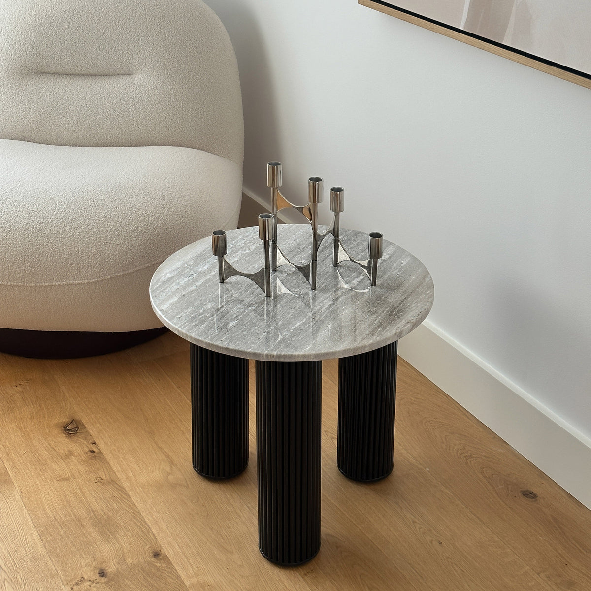 Travertine round side table adjacent to chair