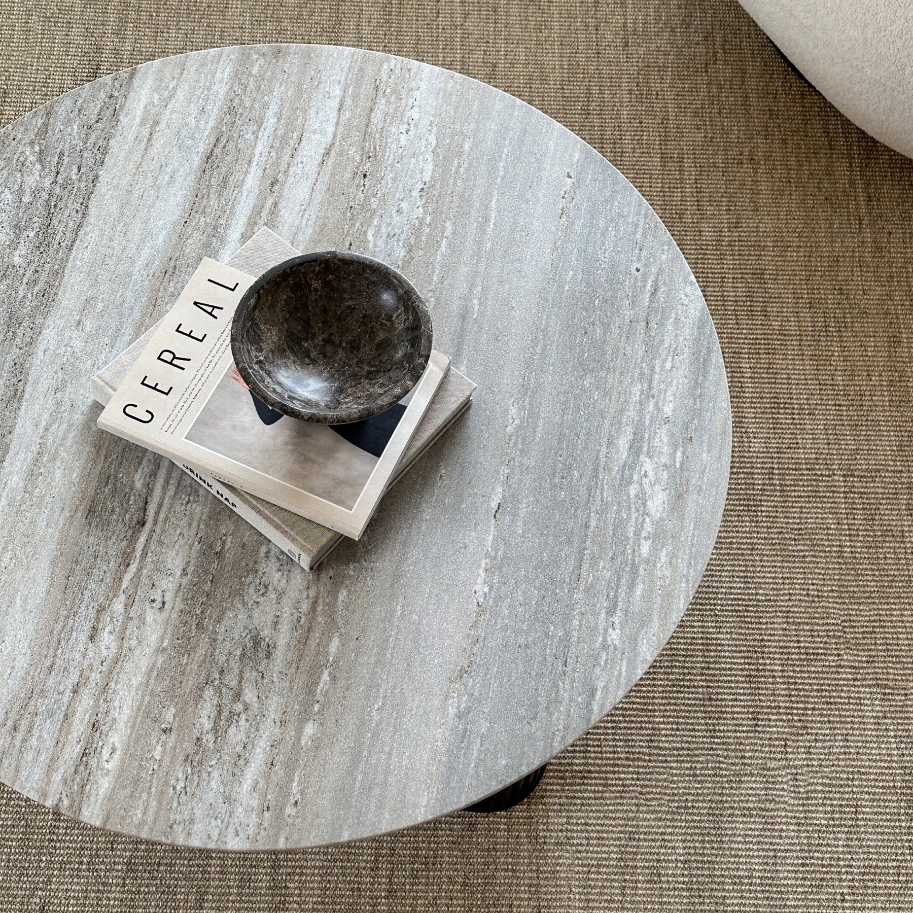 Travertine round large coffee table adorned with books and bowl