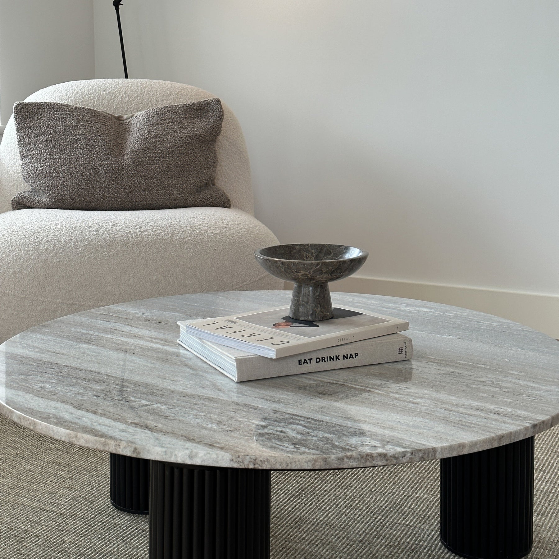 Travertine round large coffee table adjacent to chair