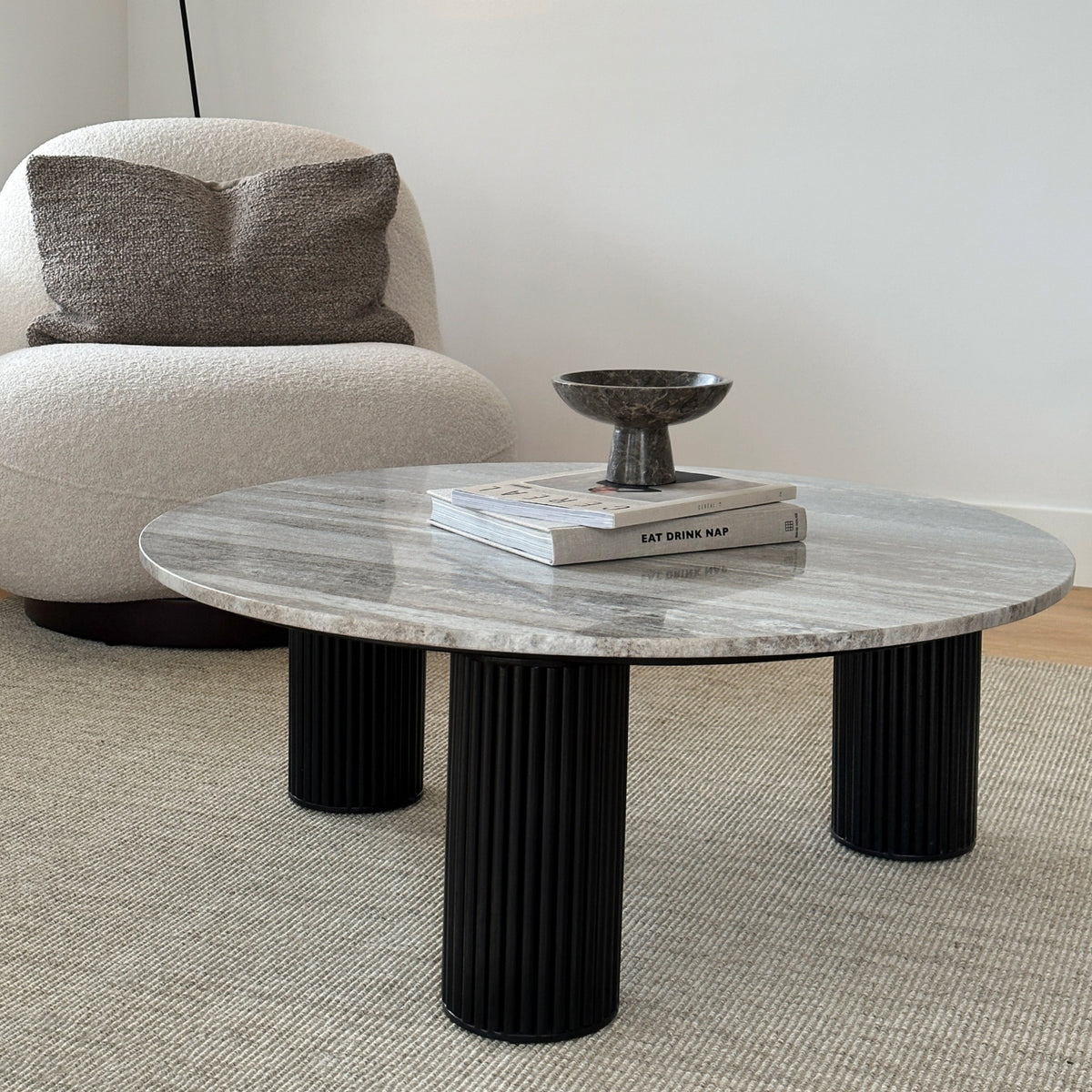 Travertine round large coffee table adjacent to chair