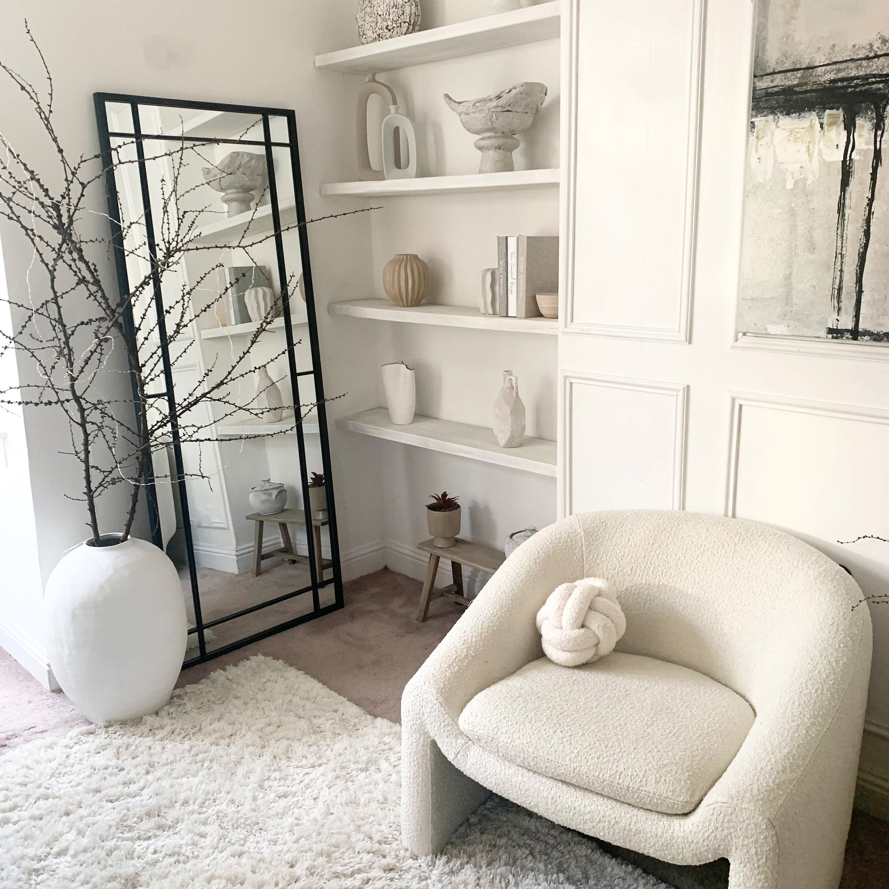 Black industrial full length metal mirror leaning against wall in lounge