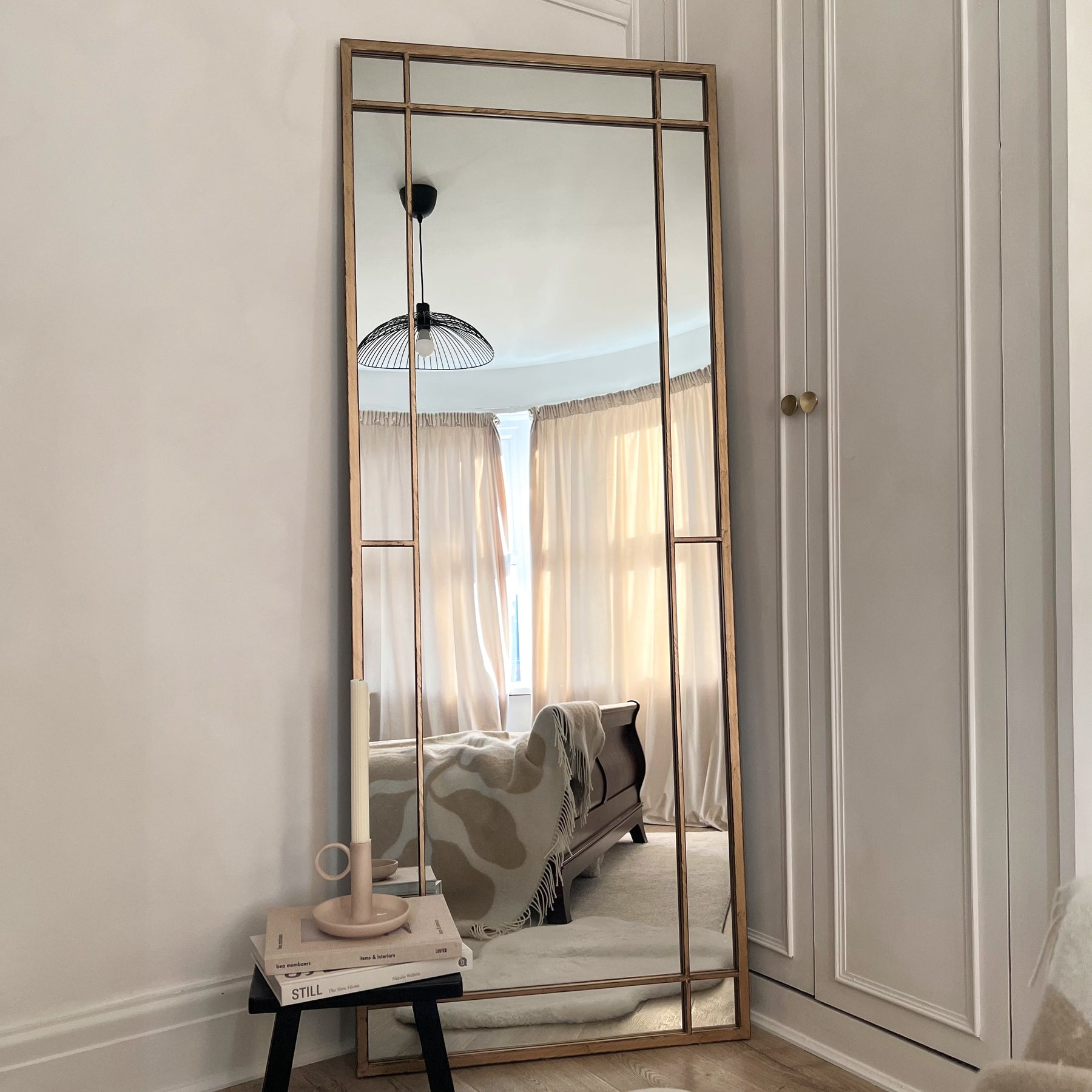 Gold industrial full length metal mirror leaning against wall