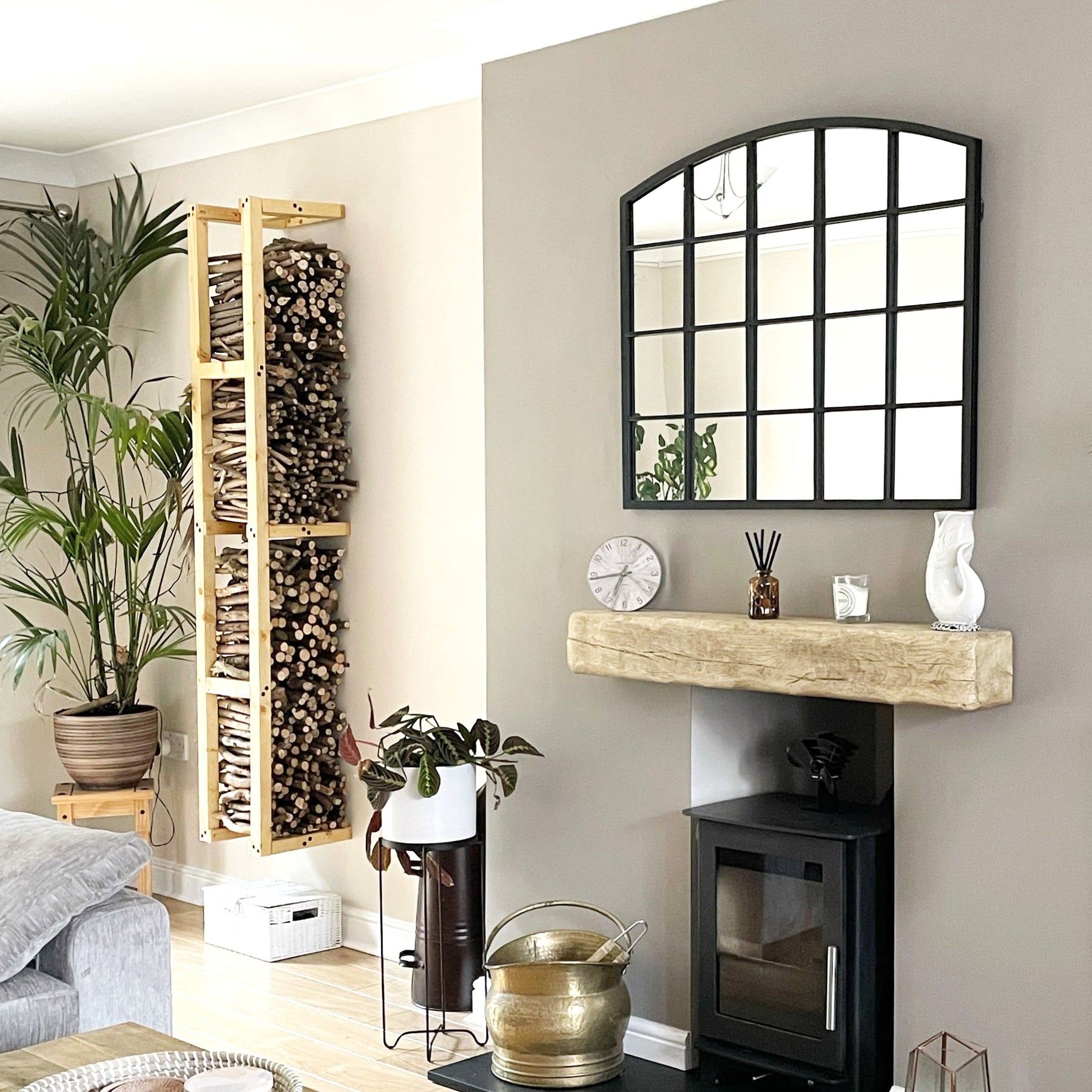 Black industrial arched metal window mirror above mantlepiece