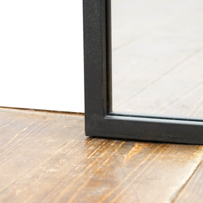 Detail shot of Full length large black metal window mirror corner