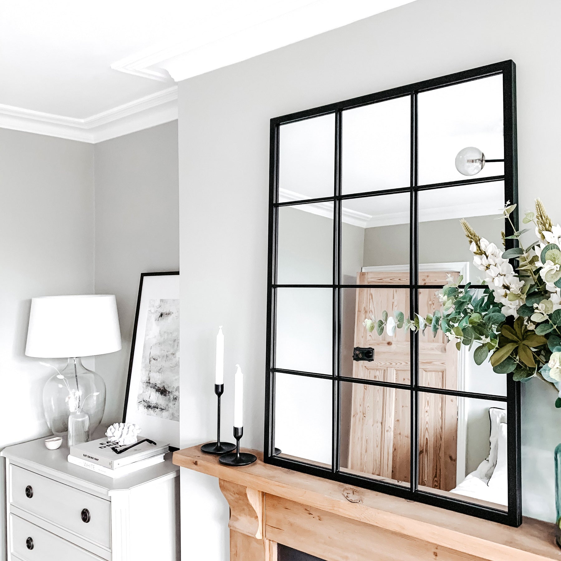 Large black industrial metal window mirror displayed above mantle