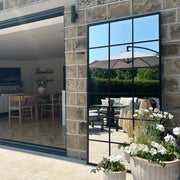 Full length large black metal window mirror as garden mirror