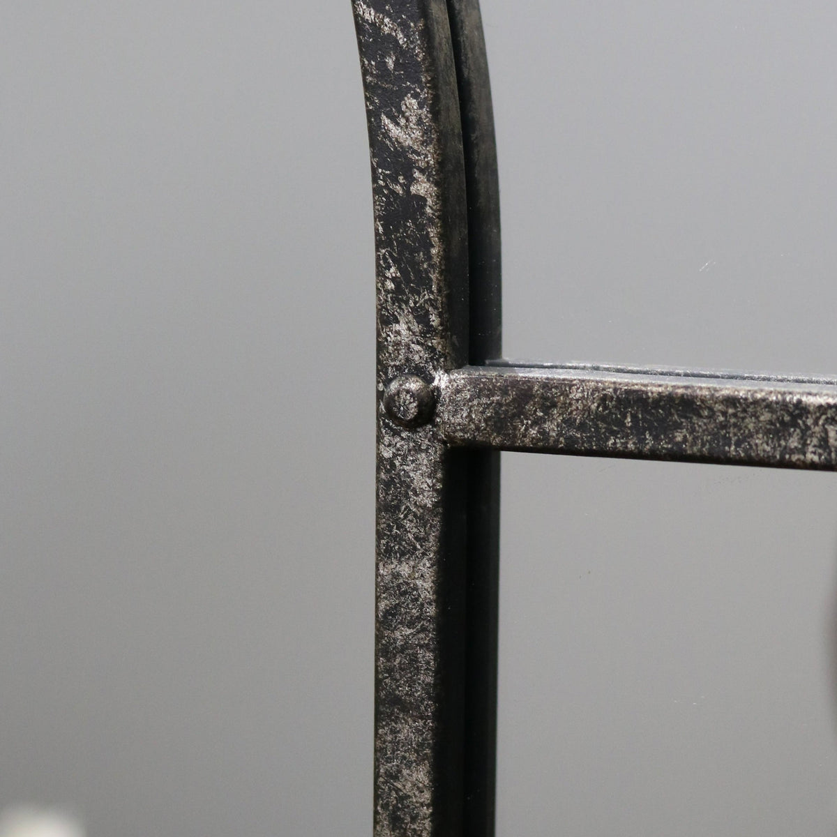 Crushed black industrial arched full length metal mirror detail shot of side