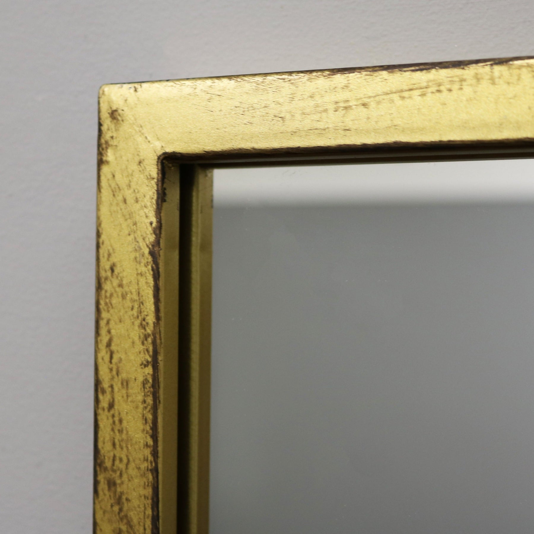 Detail shot of Full length large gold industrial metal window mirror corner