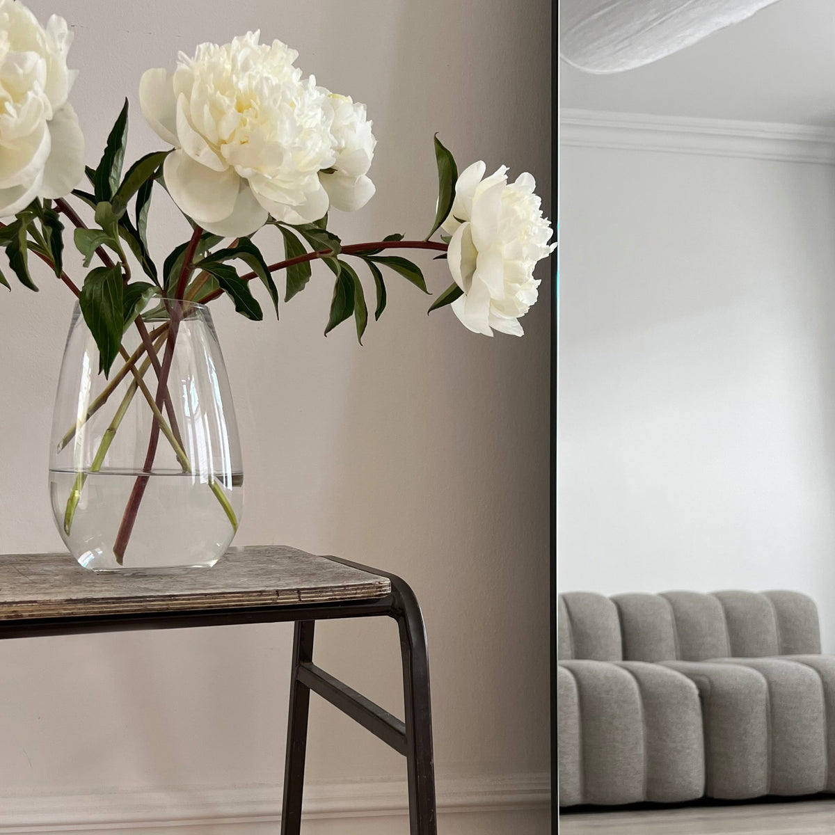 Extra large frameless arched full length mirror beside sofa