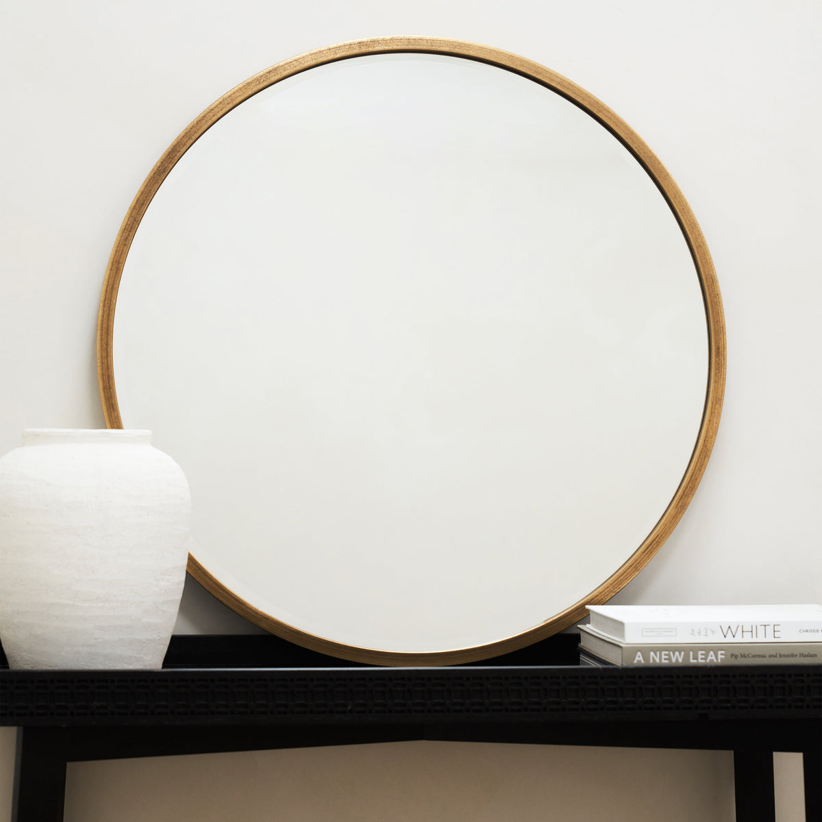 Gold Metal Modern Round Wall Mirror beside books
