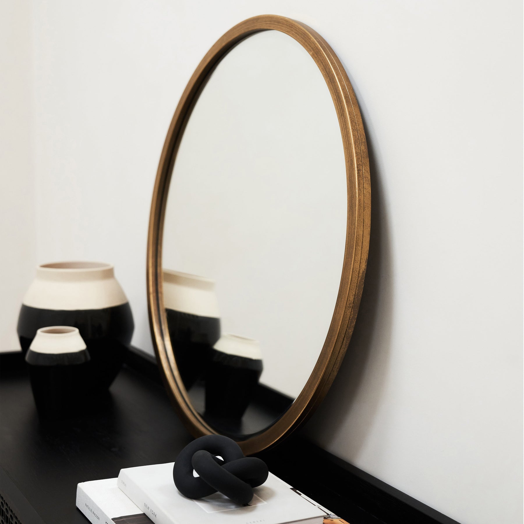 Gold Metal Modern Round Wall Mirror leaning against wall