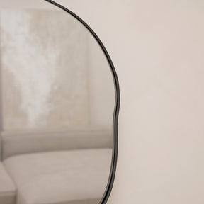 Black metal pond shaped irregular wall mirror closeup