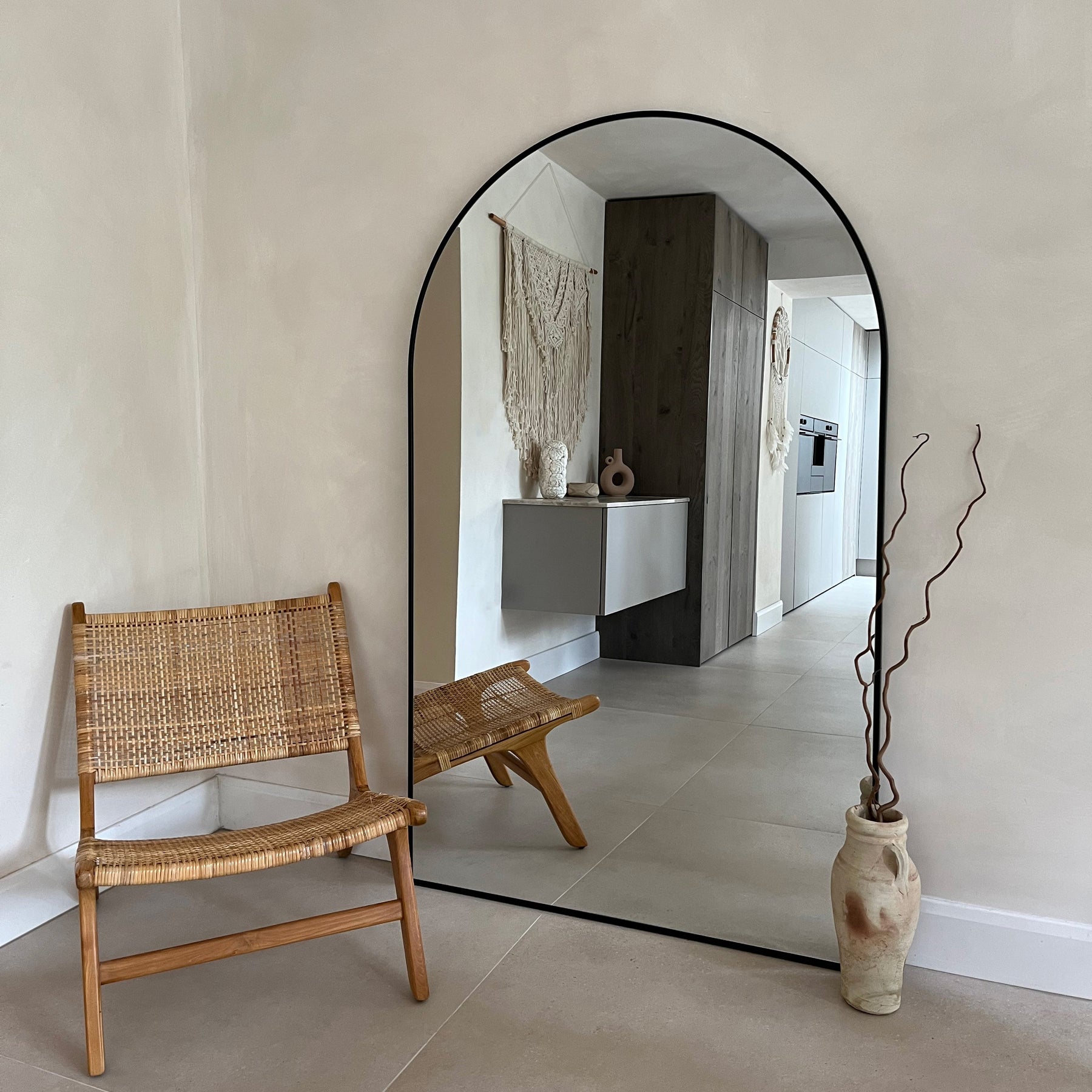 Black Full Length Arched Metal Mirror beside chair