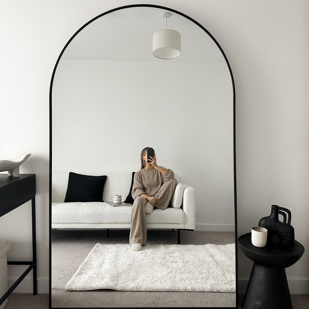 Black Full Length Arched Metal Mirror beside chair