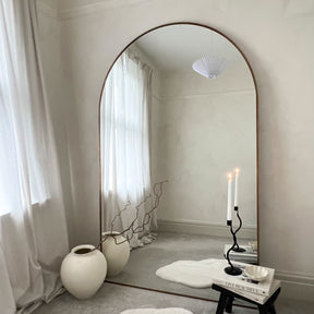 Gold Full Length Arched Metal Mirror adjacent to vase