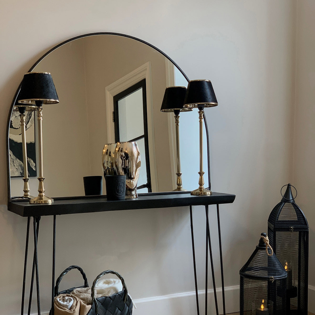 Black Wide Arched Metal Overmantle Mirror on console table