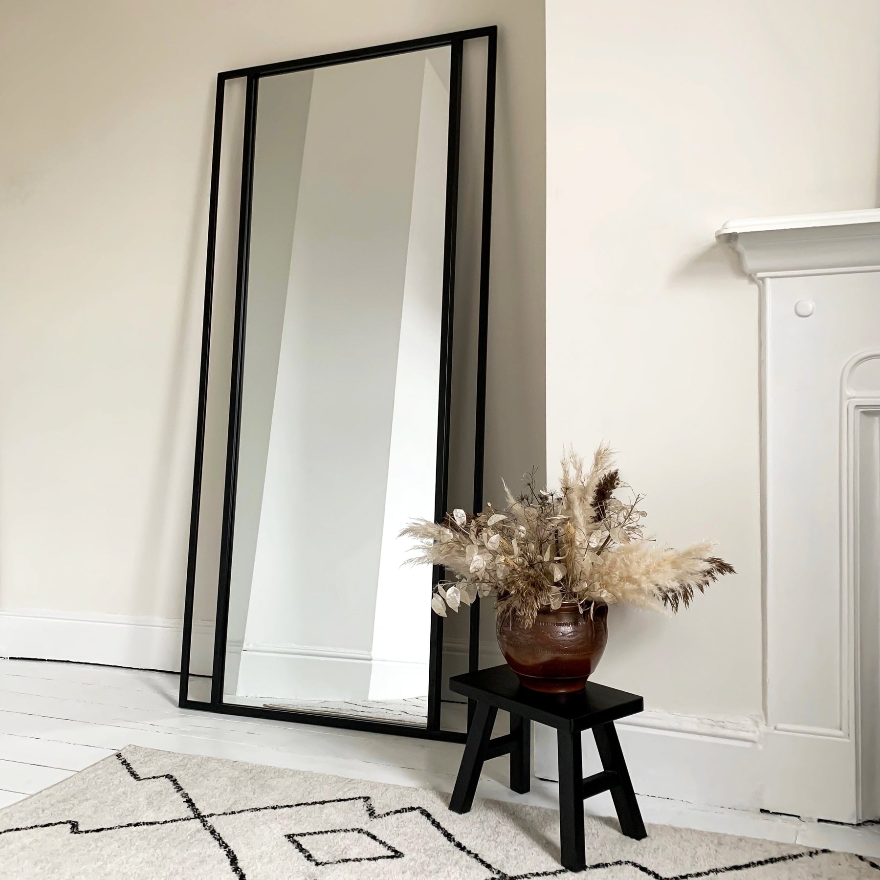 Full Length Black Metal Mirror beside fireplace