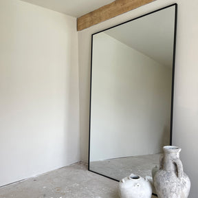 Full Length Black Extra Large Metal Mirror beside rustic vases