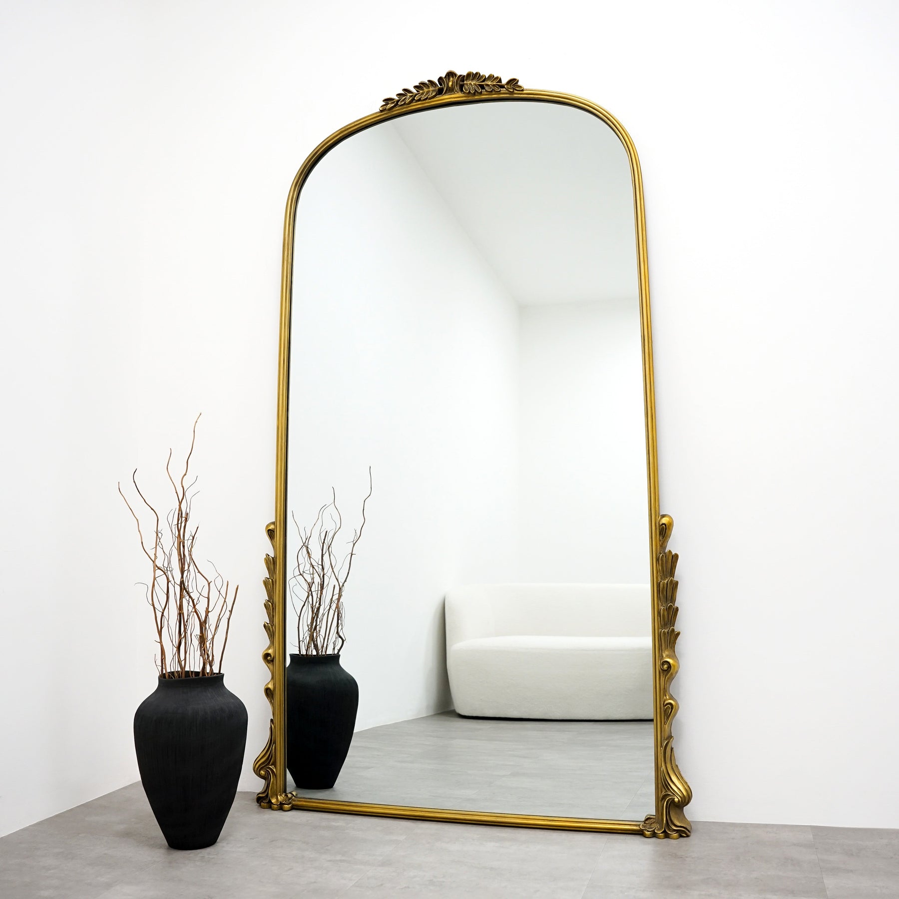 Full Length Gold Arched Ornate Metal Mirror beside vase