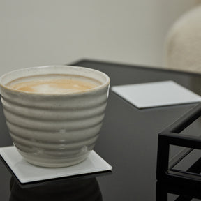 White coaster with a coffee mug placed on it