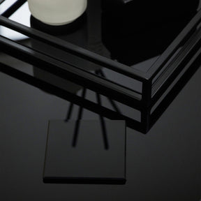 Black coaster on mirrored glass black table