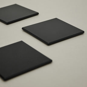 Three black coasters on table