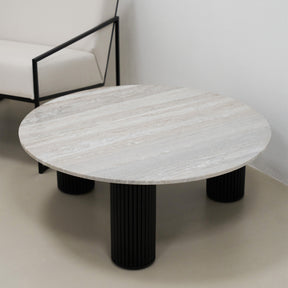 Travertine round large coffee table adjacent to chair