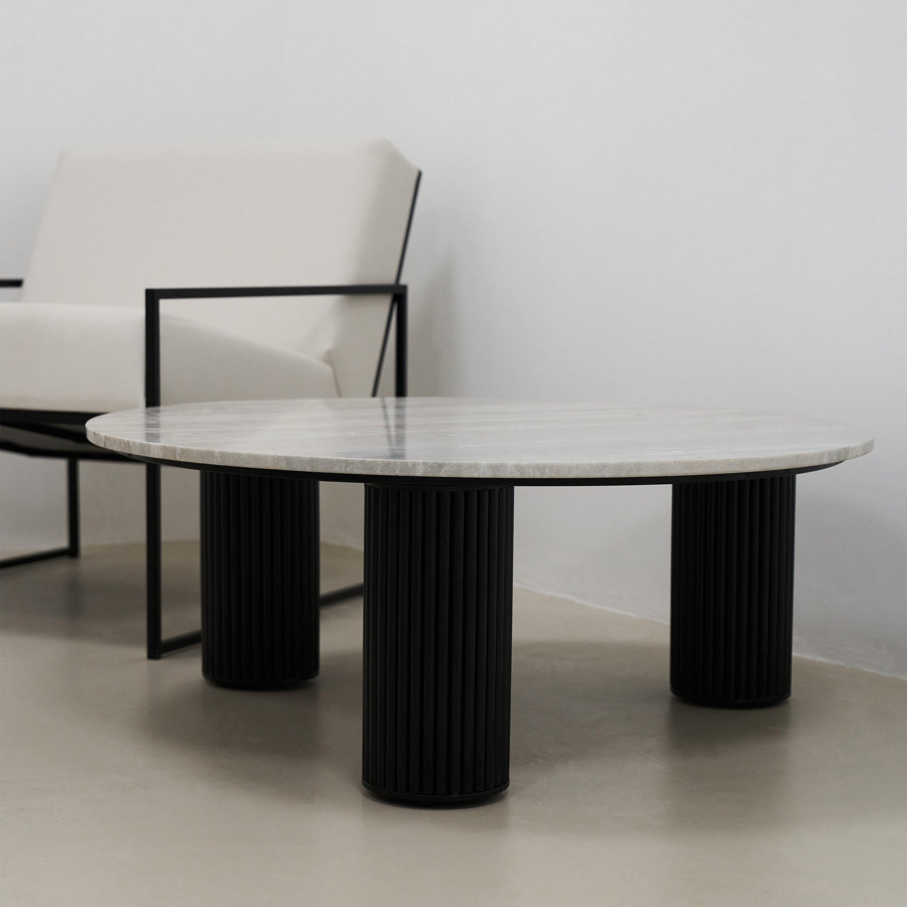 Travertine round large coffee table adjacent to chair