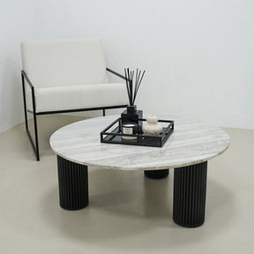 Travertine round large coffee table adjacent to chair