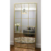 Full length large gold industrial metal window mirror leaning against wall