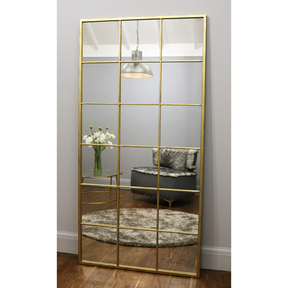 Full length large gold industrial metal window mirror leaning against wall