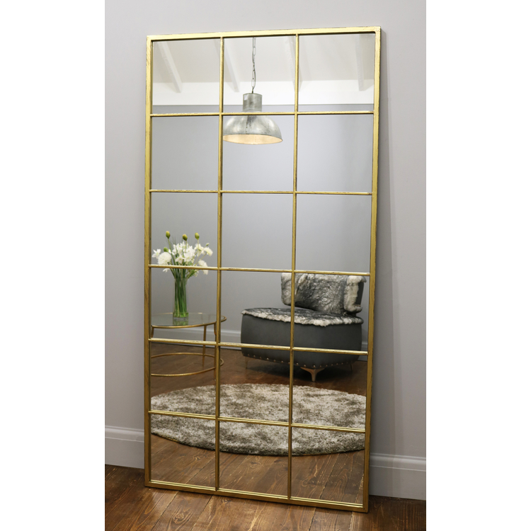 Full length large gold industrial metal window mirror leaning against wall