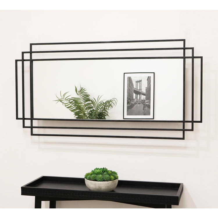 Large black rectangular metal mirror displayed on wall